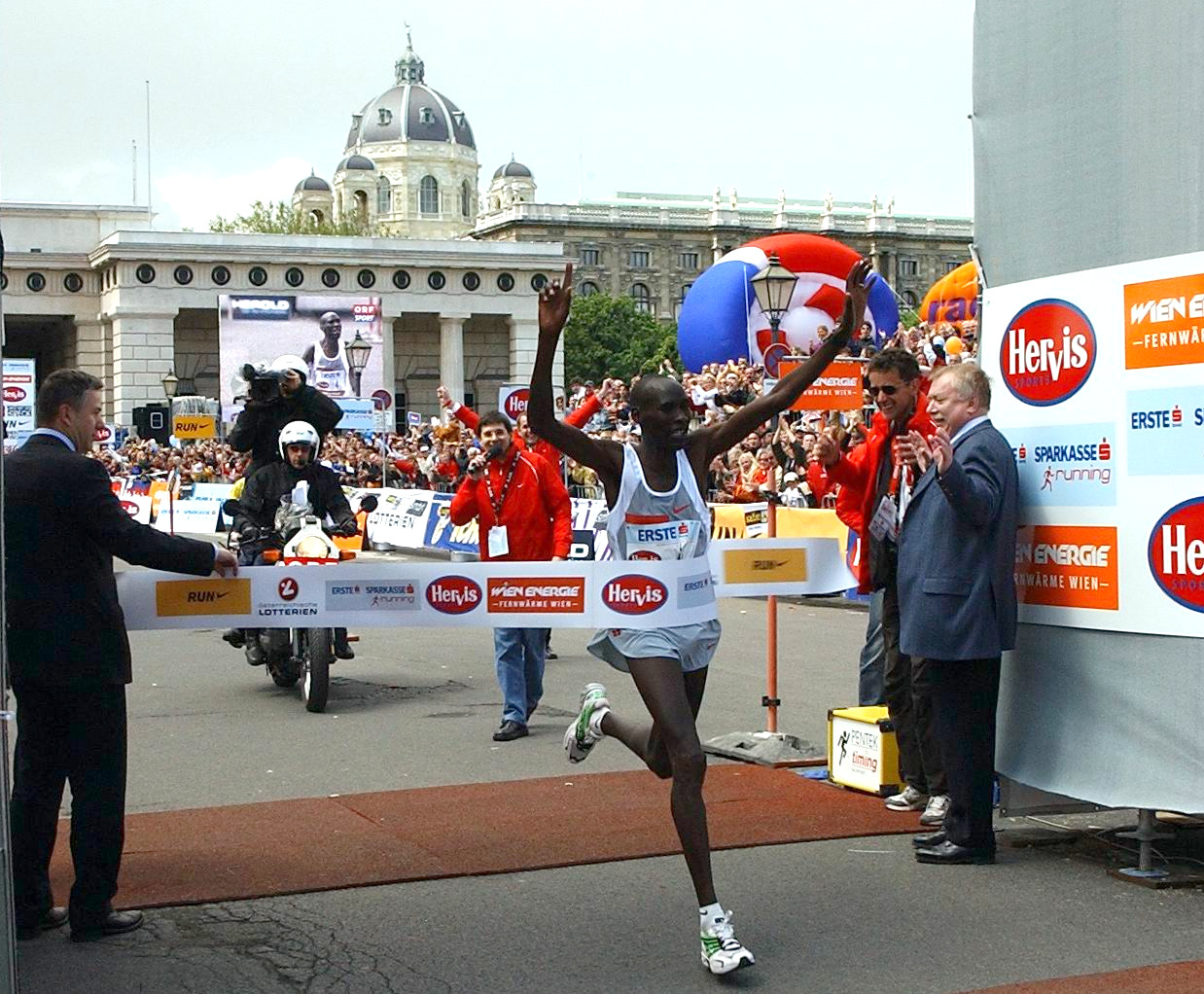 Samson Kandie bei seinem VCM-Sieg 2004. Die damaligen Bürgermeister von Wien und Berlin, Michael Häupl und Klaus Wowereit, halten das Zielband. Bild: VCM / ActionPhoto